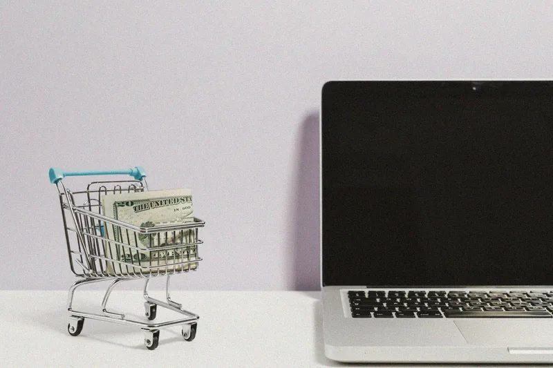 Xe đẩy hàng nhỏ cạnh laptop.