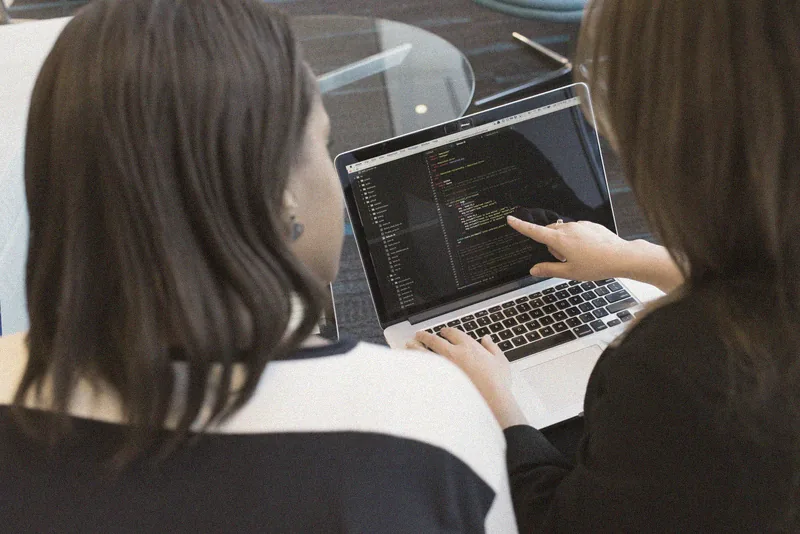 Hai lập trình viên xem code trên màn hình.